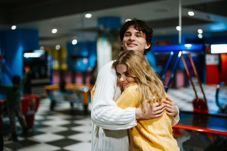 Young couple enjoys a fun moment at an arcade in a vibrant gaming centerの写真素材