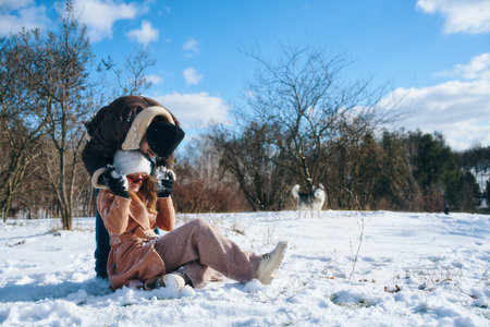 Couple enjoying playful winter activities in a snowy landscape