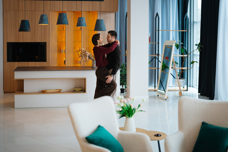Couple dancing together in a modern living room during the dayの写真素材