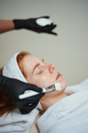 Spa treatment focusing on facial application in a calm environmentの写真素材