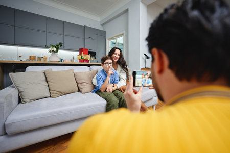 Family captures a joyful moment together in a bright living roomの写真素材