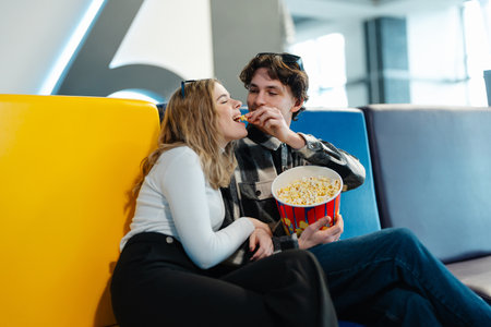 Young couple sharing popcorn while enjoying time together in a modern setting
