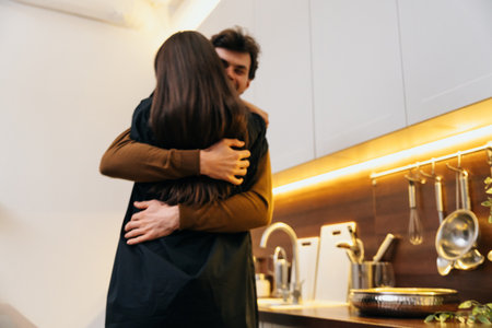 A couple sharing a warm embrace in a cozy kitchen during the evening
