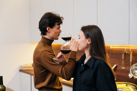 Couple enjoying wine together in a cozy kitchen during a romantic evening