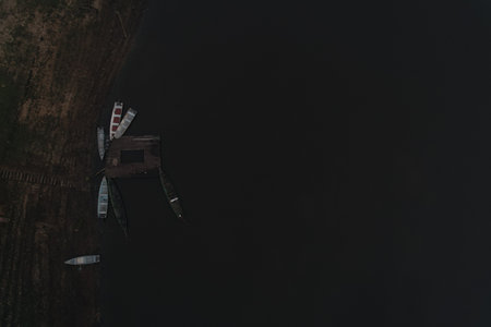 Boats docked at a remote wooden pier in a quiet natural settingの写真素材