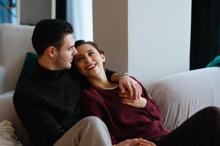Happy couple enjoying cozy moment indoors during winter afternoonの写真素材