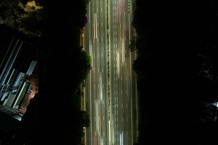 Nighttime traffic flows swiftly along a busy urban highway