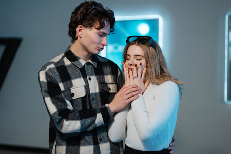 Young couple enjoys playful moment inside modern venue at nighttime