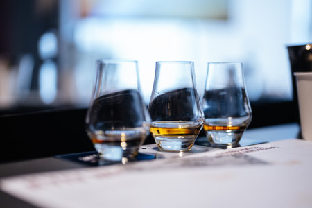 Enjoying a whiskey tasting experience in a modern bar setting with friendsの写真素材