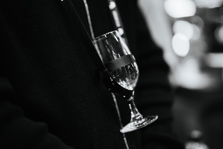 Elegant glass held casually during a night of social gatherings and conversationの写真素材