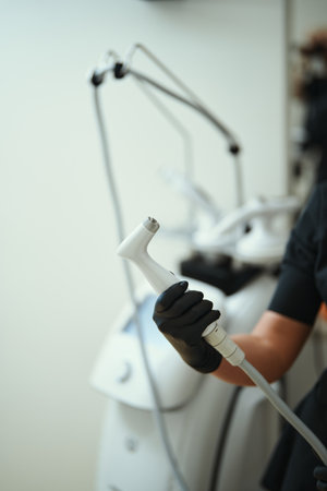 Hand holding a device for skin treatment in a clinical environmentの写真素材