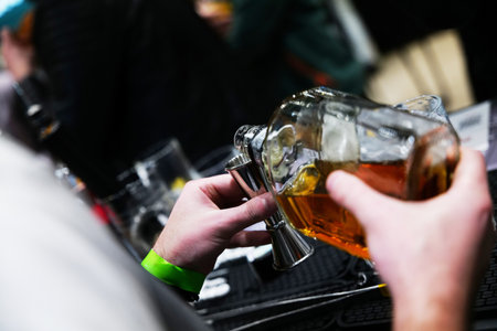 Pouring a rich amber brew at a vibrant craft beer festival ambianceの写真素材