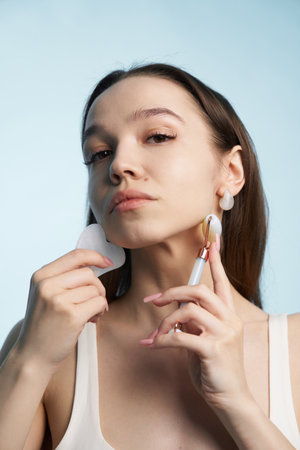 Woman applying skincare treatment using beauty tools indoorsの写真素材