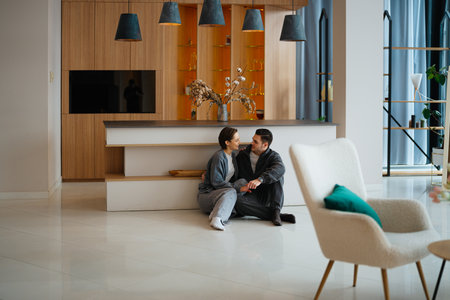 Couple enjoying quality time in a modern living room settingの写真素材