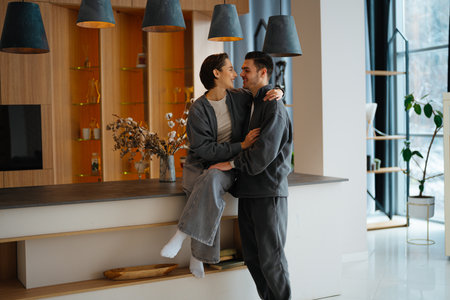 Happy couple enjoying quality time in a modern kitchen settingの写真素材