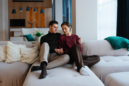 Couple enjoying a cozy moment together in a modern living room settingの写真素材