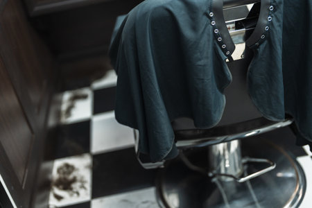 Checkered floor and barber chair await the next haircut in a cozy salonの写真素材