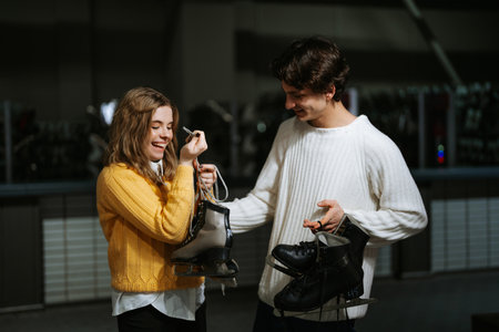 Young couple enjoying ice skating preparations in a cozy rink atmosphere