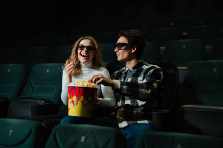 Couple enjoys popcorn while watching a movie in a theater