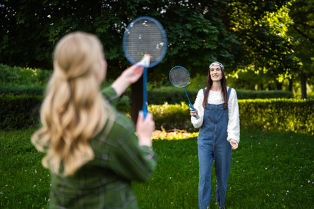 Friends enjoying a sunny day playing badminton in a vibrant green park