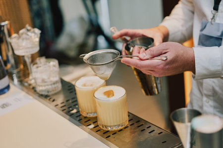 Bartender prepares cocktails at bar during service