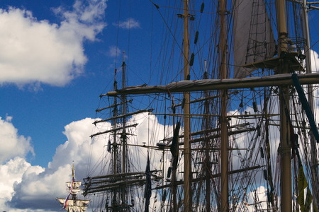 Tall ship masts and rigging silhouetted against a brigth blue sky