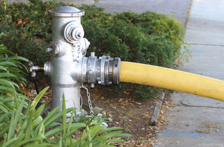 Yellow fire hose connected to a fire hydrantの写真素材