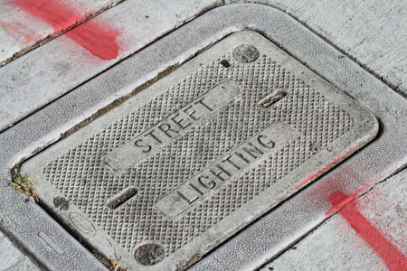 A manhole cover that reads street lightingの写真素材