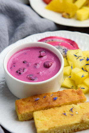 Mango bread with plant-based yogurt and fresh fruits, bright colors, colourful meal, 45 degree angle, close-upの写真素材