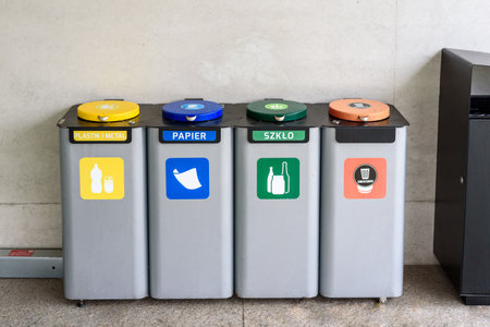 Waste containers for garbage segregation in Poland, standing next to a wallの写真素材