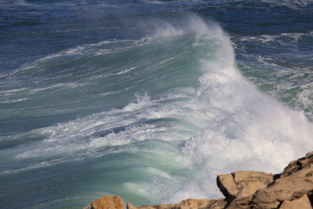 Marine wave breaks against offshore stoneの写真素材