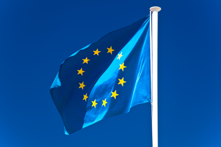 European Union flag flying in front of bright blue skyの写真素材