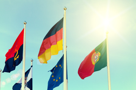 Row of national flags against blue sky