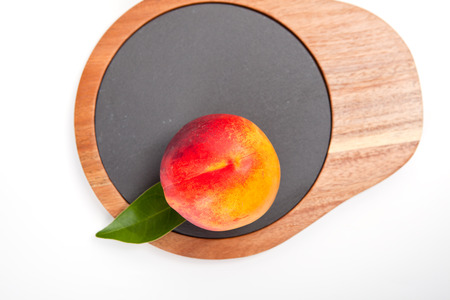 Freshly washed peach  on wooden cutting board isolated on white background