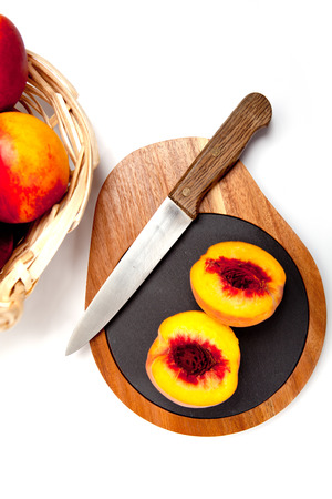 Freshly washed peach  on wooden cutting board with knifeの写真素材