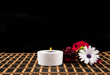 Spa  scene - aromatherapy candle and flower on a black backgroundの写真素材