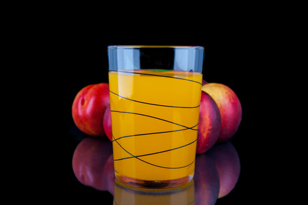 Peach juice in a glass on black background の写真素材