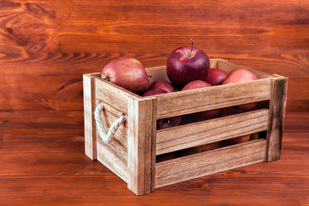 Fresh and delicious red  apples in a wooden crate on a white background . の写真素材
