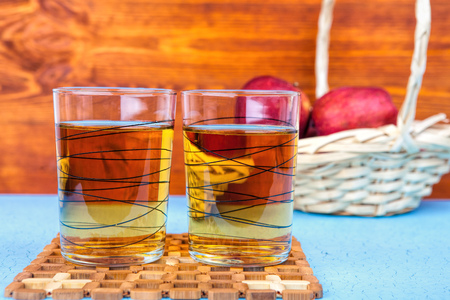 Two glasses of apple juice and red apples on wooden background .の写真素材