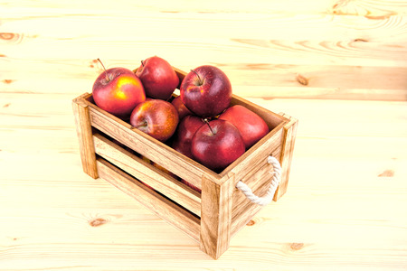Fresh and delicious red  apples in a wooden crate on a white background .の写真素材
