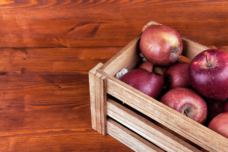 Fresh and delicious red  apples in a wooden crate on a white background . の写真素材