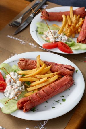 Grilled sausages with potatoes and vegetable garnishの写真素材