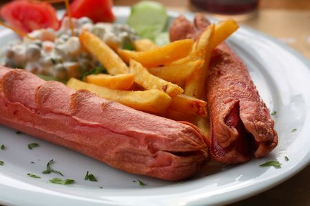 Grilled sausages with potatoes and vegetable garnishの写真素材