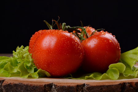 Bunch of tomatoes on black backgroundの写真素材
