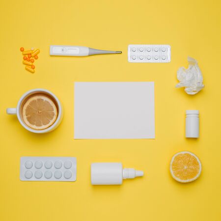 Pills, medical thermometer, nose spray and lemon. Different medications on yellow background. Cold and flu home remedies. Disease self-treatment concept. Flat lay. Top view with blank space for text.の写真素材