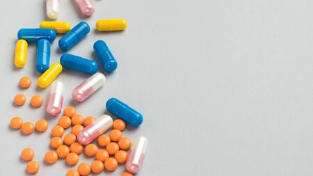 Colorful pills and capsules, medication on gray background with copy space. Health and medication...