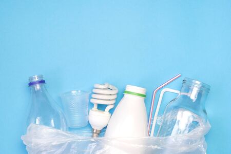 Different types of garbage on blue background. Sorting waste and recycling concept. Ecology and environmental care. Top view flat lay with copy space.の写真素材