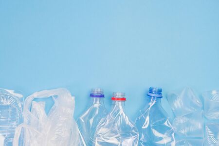Different plastic garbage on blue background. Plastic waste recycling concept. Ecology and environmental care. Top view flat lay with copy space.の写真素材