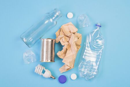 Different types of garbage on blue background. Sorting waste and recycling concept. Ecology and environmental care. Top view flat lay.の写真素材