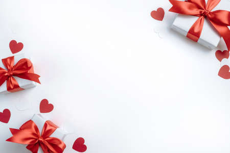 Gift boxes with red ribbon and hearts on white background. Valentines day banner with free space. Top view, flat lay.の写真素材